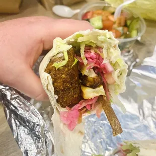 a hand holding a burrito