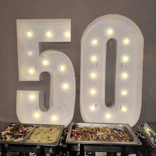 the number 50 and a buffet of food