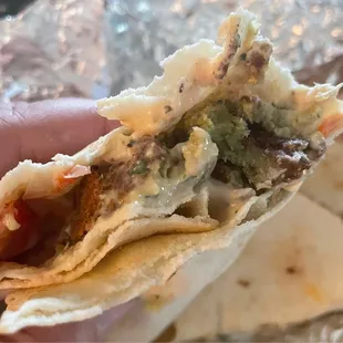 a hand holding a tortilla