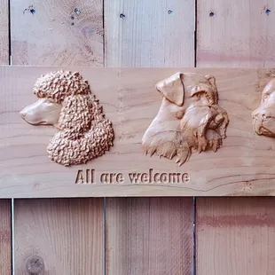 three dogs carved into a wood plaque