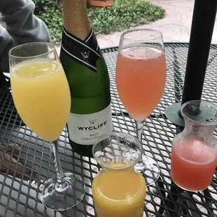 wo glasses of orange juice and a bottle of wine