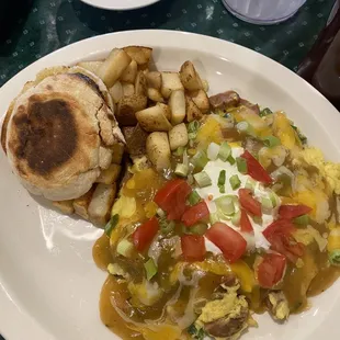 a plate of food with eggs, potatoes, and a sandwich