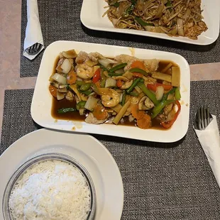 two plates of food and a bowl of rice