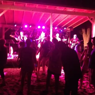 a group of people dancing on the beach