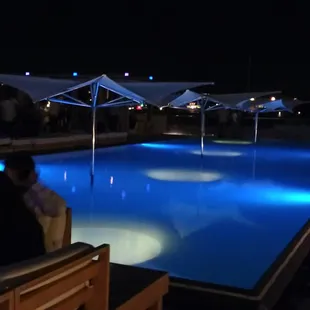 people sitting by the pool at night