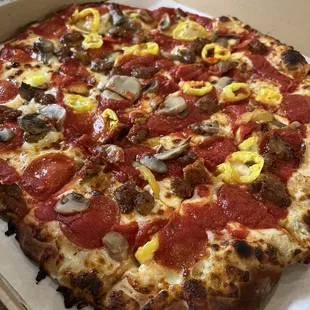 Pizza with pepperoni, mushrooms, sausage and banana peppers.