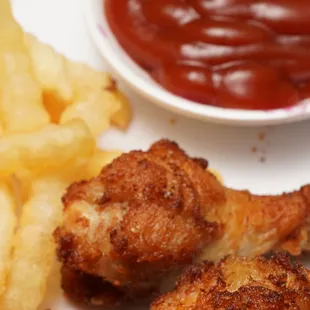 a plate of fried chicken and french fries with ketchup