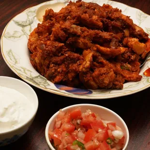 a plate of fried chicken and a bowl of salsa