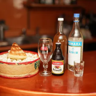 a table with a basket of food and a glass of wine