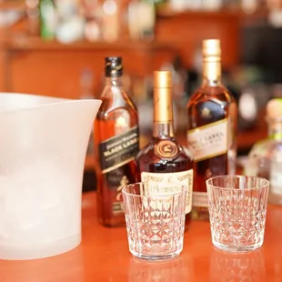 bottles of alcohol and glasses on a bar counter