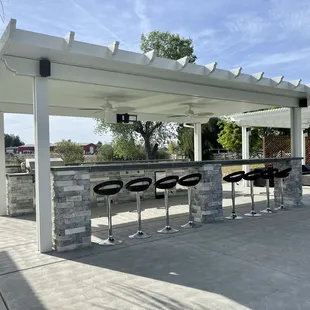 Outside kitchen with bar and patio cover.