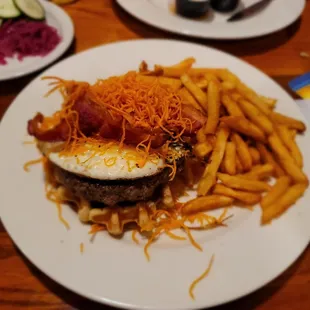 Waffle, burger, fried egg, bacon and sweet potato nest with fries
