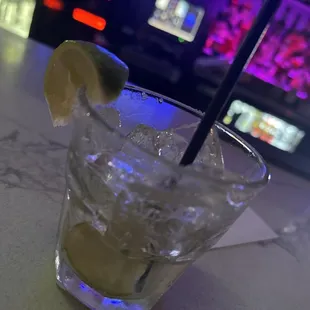 a glass of lemonade with a black straw