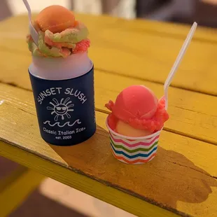 Rainbow slush in koozie and small sunset slush