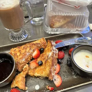 a plate of french toast with strawberries and berries