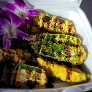 a container of food with a purple flower