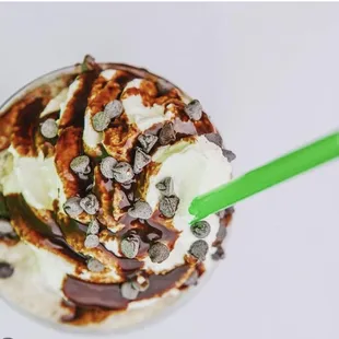 a milkshake topped with chocolate chips and whipped cream