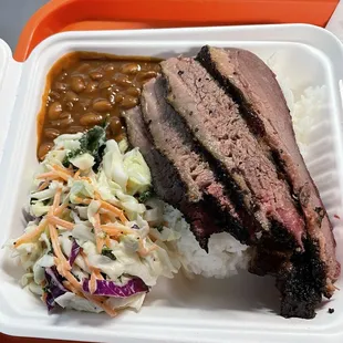 Brisket plate with rice, cole slaw, and baked beans.
