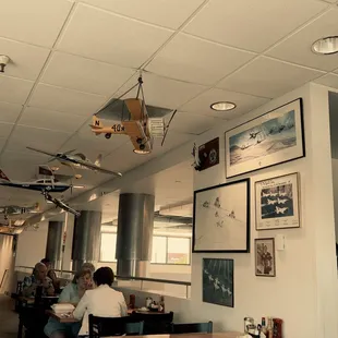 The decor includes vintage airplanes in the café