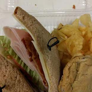 a sandwich and chips in a styrofoam container