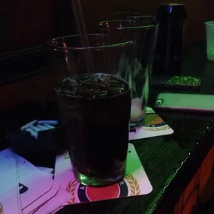 a glass of soda and playing cards