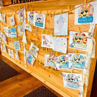 children&apos;s artwork on a wooden wall