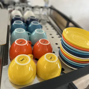 a tray of colorful cups and saucers