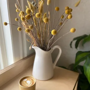 a cup of cappuccino and dried flowers
