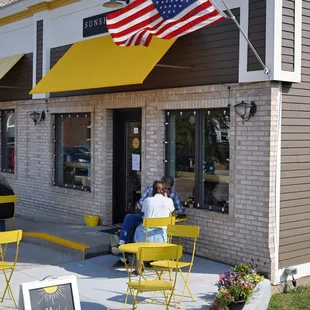two people sitting outside of a coffee shop