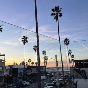 a view of a busy street with palm trees