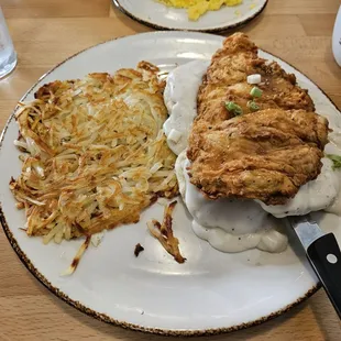 Chicken Biscuits - Chicken Fried Chick drizzled with honey on 2 Biscuits with Gravy, Hashbrowns and an egg on top.
