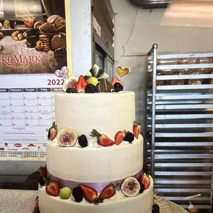 a three tiered cake with fruit on top