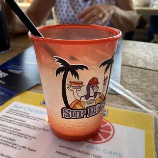 a woman sitting at a table with a drink