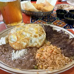 Chilaquiles with carne asada and over hard eggs