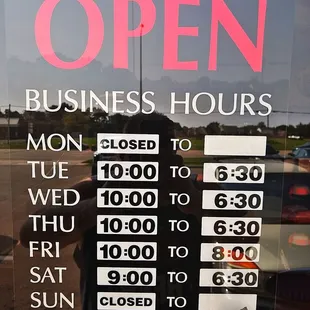 a business hours sign in a window