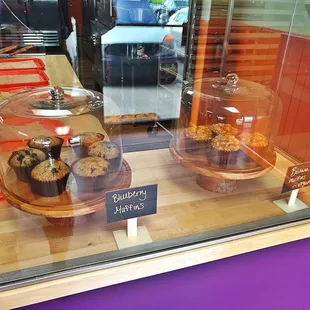 a variety of baked goods displayed in a glass case