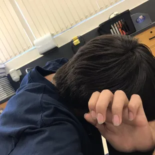 a man sitting at a desk with his head in his hands