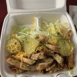 Grilled chicken with a little bit of lettuce and 4 sad pickles