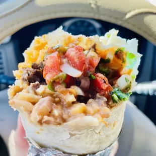 a hand holding a burrito