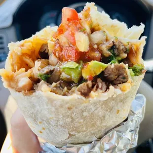 a hand holding a burrito