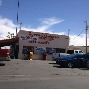 a blue car parked in front of a store