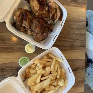 a chicken and french fries in a styrofoam container