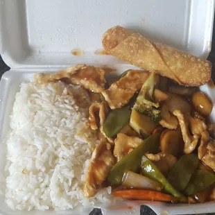 a takeout box with rice, chicken, and vegetables