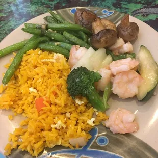 a plate of rice, vegetables, and shrimp