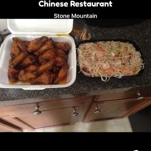 a plate of chicken wings and a bowl of noodles