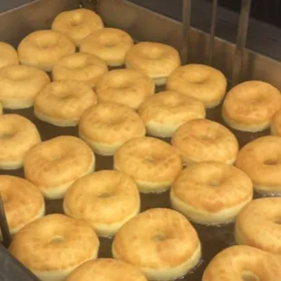 the doughnuts being cooked in a fryer
