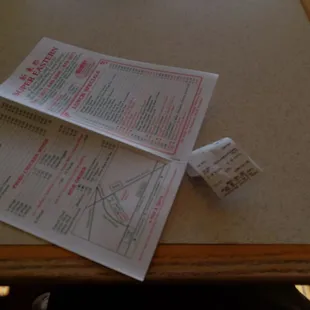 a table with a menu and a roll of toilet paper