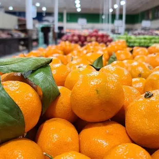 a pile of oranges in a grocery store