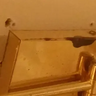 Metal lighting fixture over the bed separating from the wall.