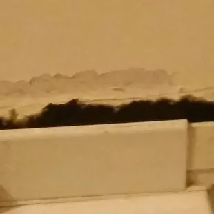 This is the gap between the air conditioner and the wall.  During the day, you could see light from outside.